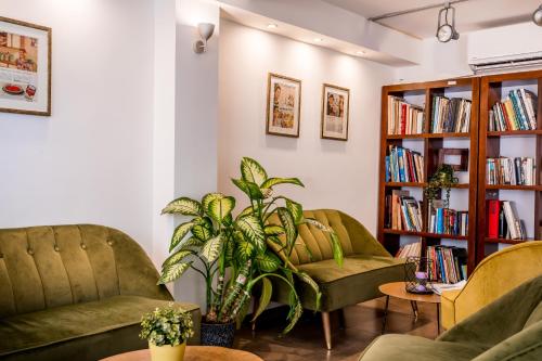 a living room with two chairs and a book shelf at Satori Hotel in Haifa