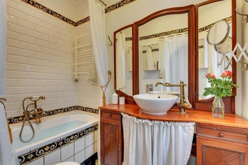 W łazience znajduje się wanna, umywalka i lustro. w obiekcie Grand Apartments - Monte Cassino Blanco w mieście Sopot