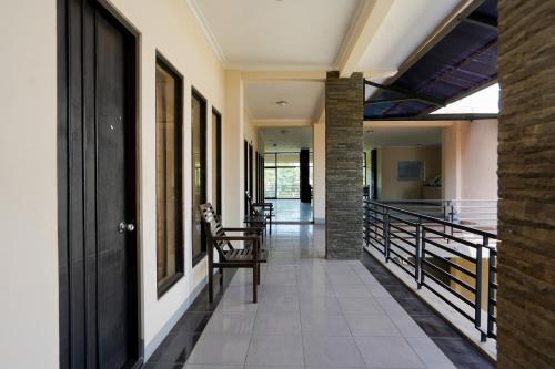 un couloir d'une maison avec une chaise et un escalier dans l'établissement Capital O 1430 Hotel Ratna Syariah, à Probolinggo