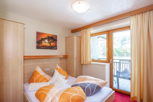 une chambre avec un lit avec des oreillers et une fenêtre dans l'établissement Trofana Appartements, à Sölden