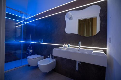 a bathroom with a toilet and a sink and a mirror at La Lupa in Matera