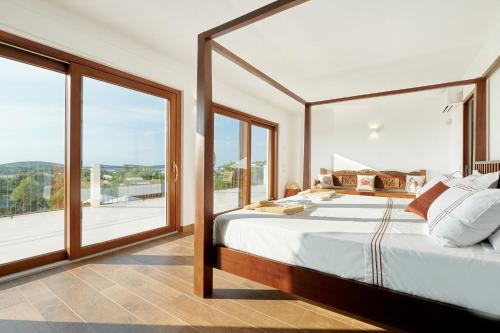 a bedroom with a large bed and large windows at Fiframar in Sant Josep de Sa Talaia