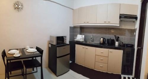 a kitchen with a counter and a table and a microwave at JSK Apartment in Bacoor