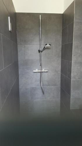a shower in a bathroom with gray tiles at Feine Herbergen Maria Magdelena in Bad Aussee