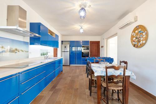a kitchen with blue cabinets and a table with chairs at Fiframar in Sant Josep de Sa Talaia