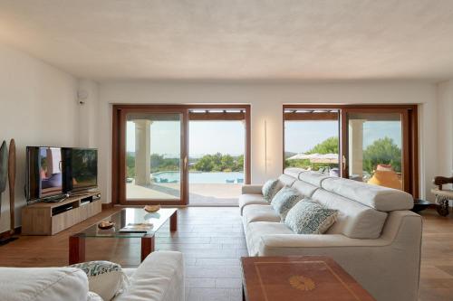a living room with a white couch and a tv at Fiframar in Sant Josep de Sa Talaia