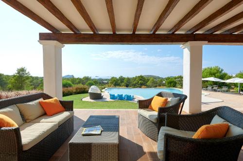 a patio with wicker furniture and a swimming pool at Fiframar in Sant Josep de Sa Talaia