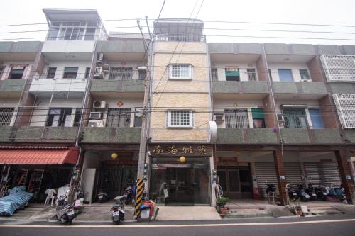 um edifício alto com um sinal em frente em 南海雅築South Sea B&B em Xiaoliuqiu