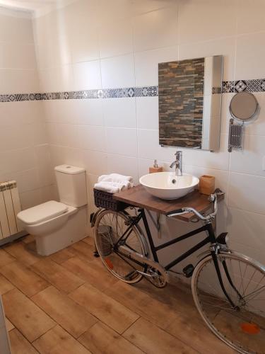 a bathroom with a bike and a sink and a toilet at Apartament Vall de Montserrat in Castellbell i Vilar