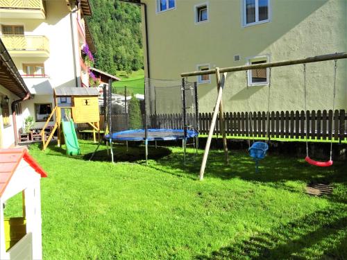 a playground in a yard next to a building at Hotel Römerhof in Fusch an der Glocknerstraße