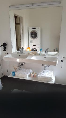 a bathroom with two sinks and a mirror at Feine Herbergen Maria Magdelena in Bad Aussee
