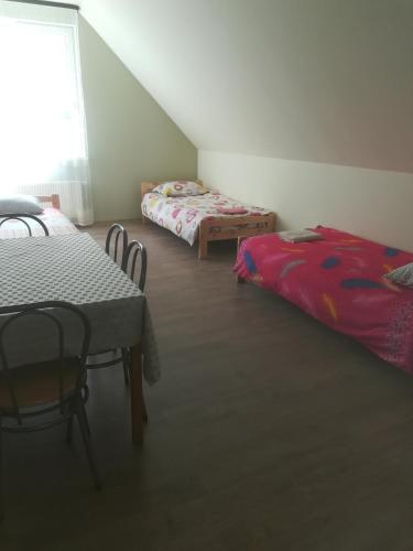 a room with two beds and a table and chairs at Višķezers in Višķi