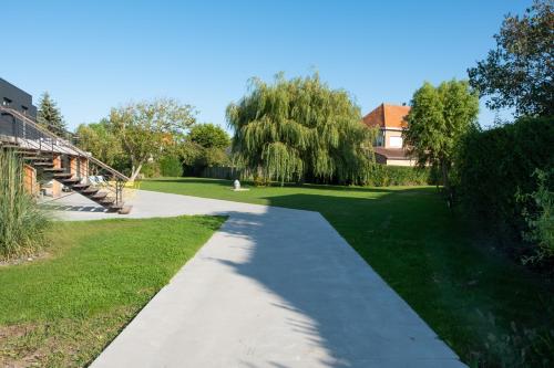 a path in a park with a tree and a house at Villa Farfalla in Bredene