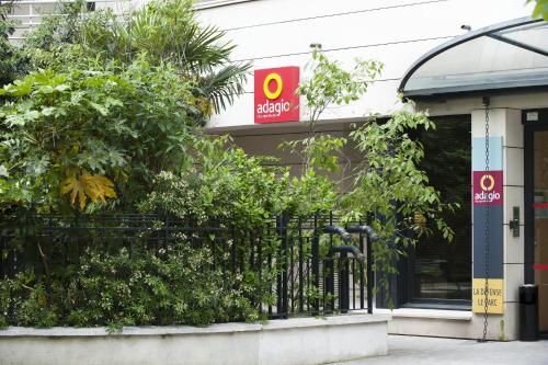a store with a sign on the side of a building at Aparthotel Adagio La Défense Le Parc in Courbevoie