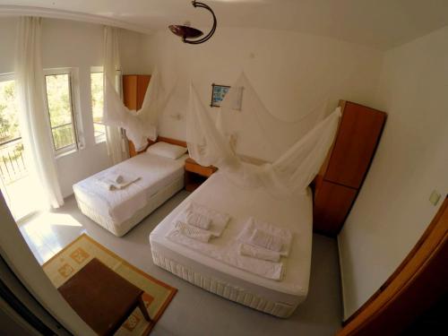 a hotel room with two beds and a window at Patara Caretta Hotel in Patara