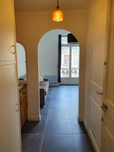 a hallway with an archway and a room with a bed at Studio Astoria in Menton