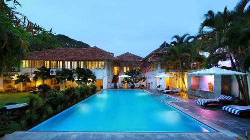 a swimming pool in front of a house at Neemrana's- Tower House in Cochin