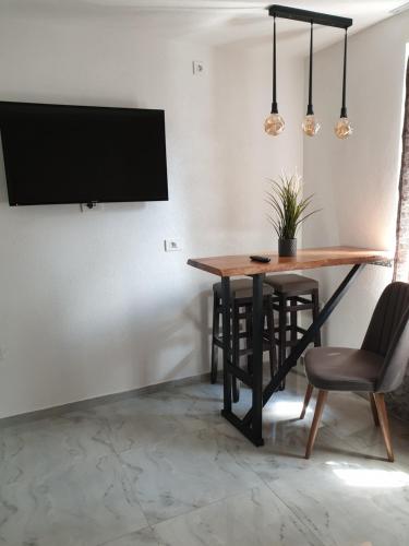 jadalnia ze stołem i krzesłami oraz telewizorem z płaskim ekranem w obiekcie Apartments Lapidarium w Ochrydzie