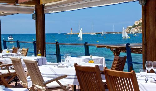 ein Restaurant mit Blick auf das Wasser und die Boote in der Unterkunft Hotel Brismar in Port d’Andratx