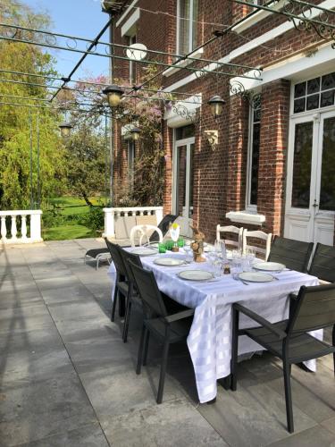 Mesnil-MartinsartにあるChambres chez l'habitant au Château de Martinsartのパティオ(テーブル、椅子付)