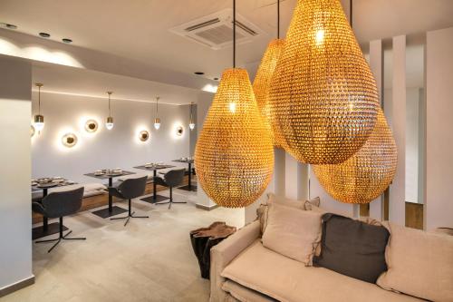 a living room with a couch and two large lights at Uma Ray Suites in Fira