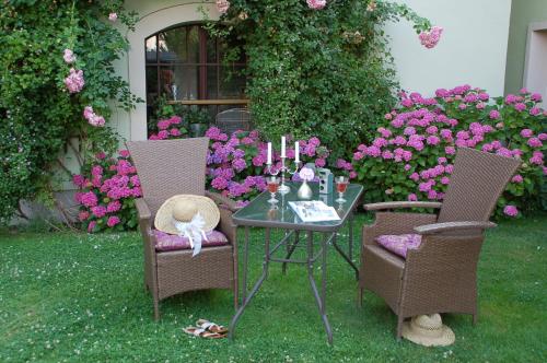 ein Tisch und zwei Stühle mit einem Tisch und Blumen in der Unterkunft Strohhutmanufaktur in Dresden