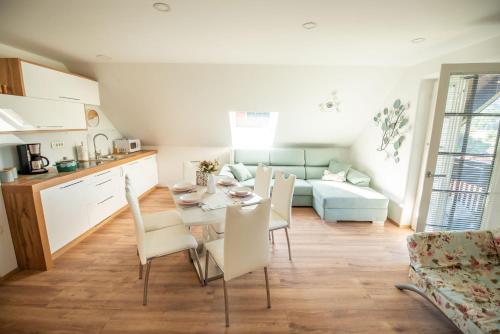 a kitchen and living room with a table and chairs at Apartmaji Urška in Laško