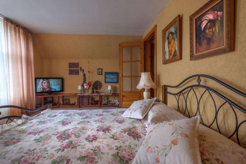 a bedroom with a large bed and a television at Second Floor Apartament in Liepāja