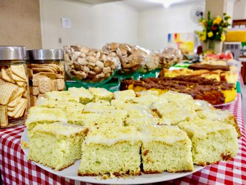 a table with a plate of cakes and other desserts at Hotel Esmig in Venda Nova do Imigrante