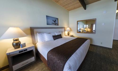 ein Hotelzimmer mit einem Bett und einem Spiegel in der Unterkunft Fireside Motel in Yachats