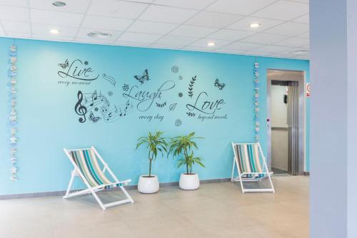 a room with two chairs and a blue wall at NURA Boreal in Playa de Palma