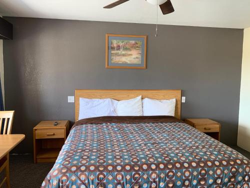 - une chambre avec un lit et un ventilateur de plafond dans l'établissement Cinderella Motel, à Wasco