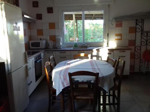une cuisine avec une table et un chiffon de table blanc dans l'établissement les murets, à Saint-Aignan