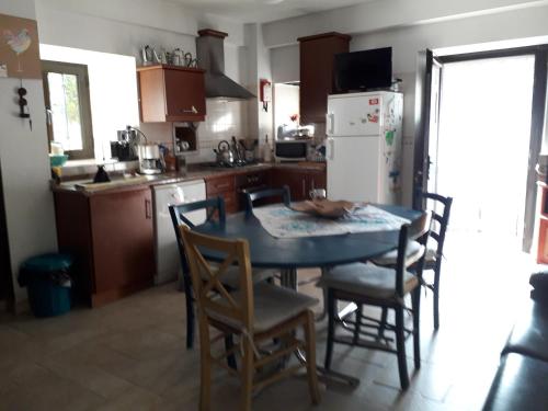 a kitchen with a table and chairs and a refrigerator at A casinha da Aldeia de Xisto in Fundão