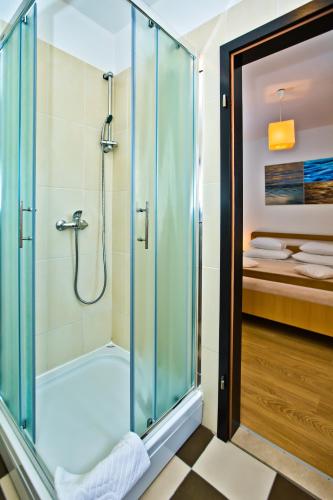 a shower with a glass door in a bathroom at HVAR apartments 8 min to the beach in Hvar