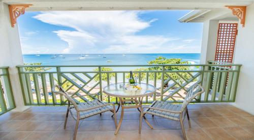 a balcony with a table and chairs and the ocean at Bay Gardens Beach Resort & Spa in Gros Islet