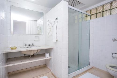 a bathroom with a sink and a glass shower at Hotel Ilhabela in Ilhabela