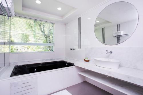 a white bathroom with a sink and a mirror at Hotel Ilhabela in Ilhabela