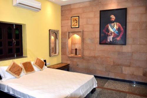 Habitación con 2 camas y una pintura en la pared. en Jodhpur Palace Guest House en Jodhpur