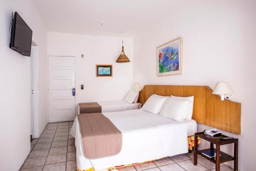 a bedroom with a bed and a tv in it at Hotel Ilhabela in Ilhabela