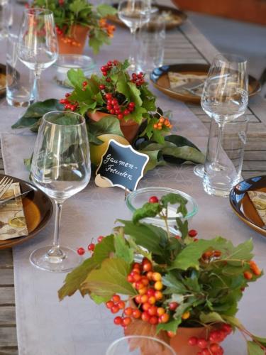 a table with plates and wine glasses and flowers on it at HEINRICHs winery bed & breakfast in Langenlonsheim
