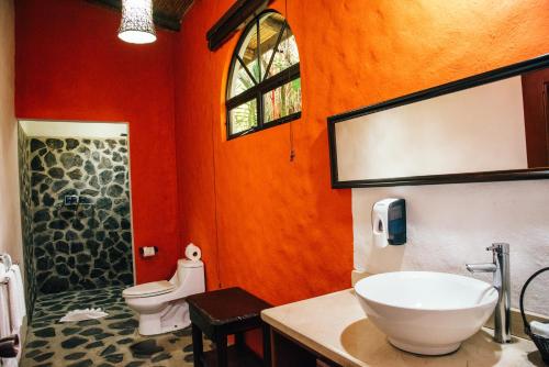a bathroom with a sink, toilet, and bathtub at Hotel Mountain Paradise in Fortuna