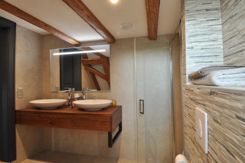 ein Badezimmer mit zwei Waschbecken und einem Spiegel in der Unterkunft Maison d'Hôtes Les Jardins de Madeleine in Bernardvillé