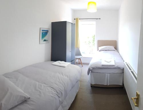 a bedroom with two twin beds and a window at Stylish living with considered workspace in Norwich