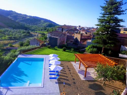 a swimming pool with a wooden bench next to a house at Mauro Home Bed and Relax in Linguaglossa