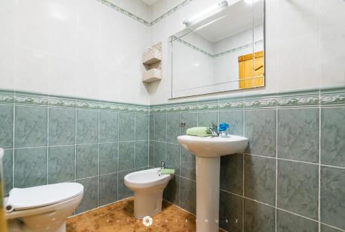 a bathroom with a toilet and a sink and a mirror at Apartamento Havana in Los Nietos