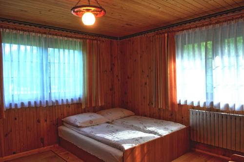 Un dormitorio con una cama en una habitación con ventana. en Dom u Małgosi, en Witów