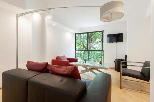 a living room with a couch and a glass table at Lovely apartment Ahuehuetes in Mexico City