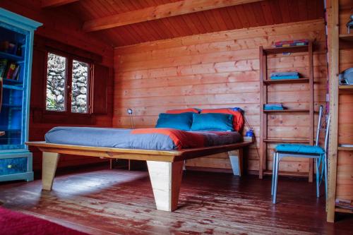 1 dormitorio con 1 cama en una cabaña de madera en Finca Pura Vida Blockhaus, en Mazo