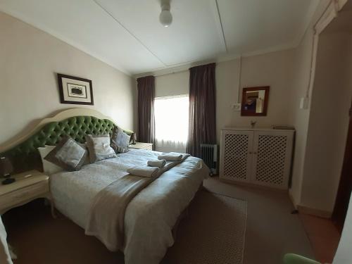 a bedroom with a large bed and a window at Sutherland Guest House in Sutherland